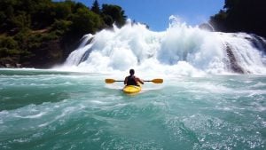 Kayaker riding a powerful river wave.