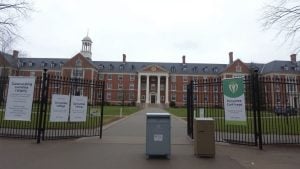 Closed college gates with empty nonprofit donation box